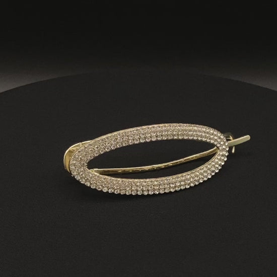 “GlitzGrip Hollow Gold Hair Clip featuring a hollow oval design with sparkling zircon gems, measuring 9.5 cm in length. Elegant and durable, perfect for various hairstyles.”