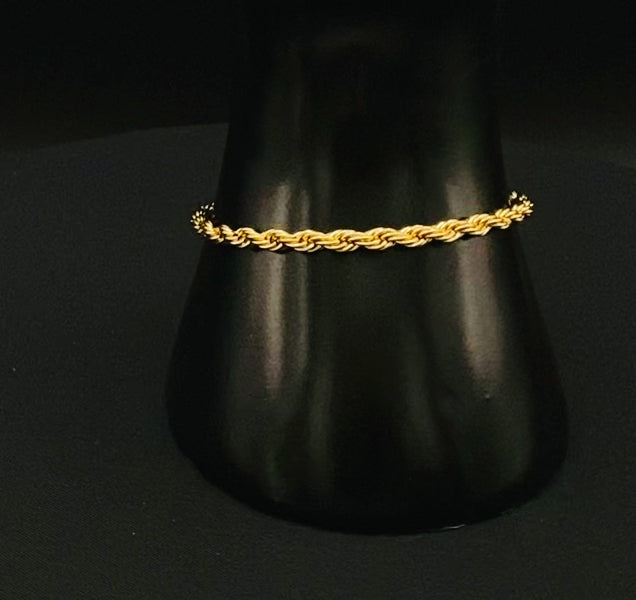 “Spiral Splendor Bracelet in gold with an intricate spiral design, featuring luxurious gold plating and PVD plating for durability. Made from stainless steel, adjustable length of 17.5 cm with a 3 cm extension.”