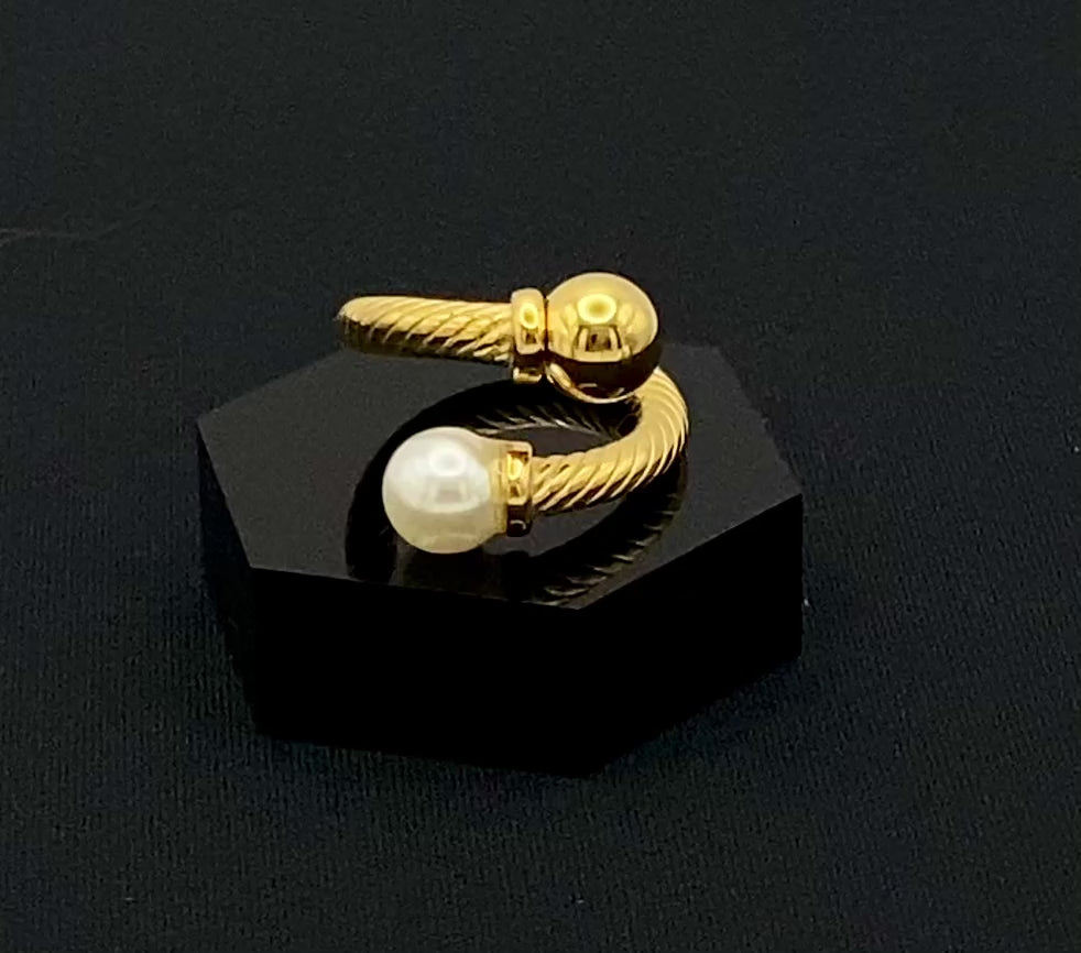 Twisted Elegance Pearl and Gold Ring: Features 18k PVD gold plating for a luxurious and durable finish. The twisted design adds a unique and elegant touch, while the pearl inlay is securely set in a claw setting. This ring is nickel-free and lead-free, making it safe for sensitive skin. It is also waterproof and non-tarnish, ensuring long-lasting beauty and wearability. Available in size 6 for a comfortable fit. Perfect for those who seek both style and substance in their jewellery.