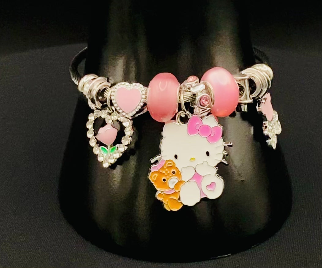 “Kitty Cartoon Character Bracelet in pink with stainless steel bangles, adorned with alloy charms, crystals, and glass beads. Features a charm with pink accents, combining playful elegance and sophistication.”