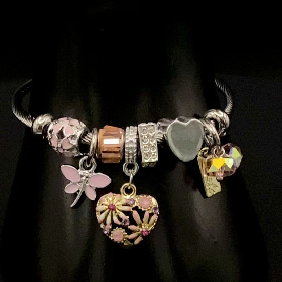 “Stellar Charm Bracelet in pink with playful charms including a heart, butterfly, and cube, crafted from high-quality stainless steel. Suitable for both women and kids, making it a perfect gift for any occasion.”