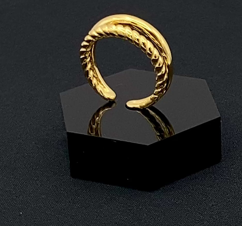 Selene Twin Band Ring Gold: This ring features a unique combination of a textured rope band and a smooth plain band, both gold plated for a luxurious finish. The titanium PVD ensures durability and resistance to wear, while the stainless steel construction adds strength and longevity. The unique twin band design combines elegance and modernity. Available in ring size 7, it is perfect for those who wear this size. Make a statement with this versatile and chic accessory that complements any look.
