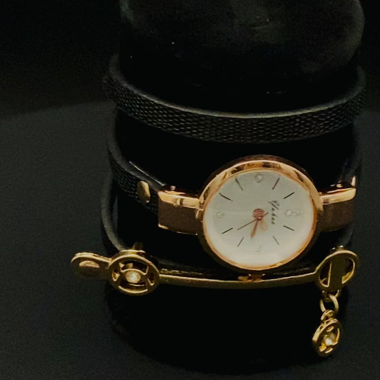 A luxurious and elegant wristwatch with a black leather strap and a gold face. Features include reliable quartz movement, sparkling crystal accents on the dial, a durable 35mm alloy case, and an adjustable 24cm band with a hook buckle clasp. Note: This watch is not waterproof. Perfect for adding a touch of charm, fashion, and luxury to any outfit.