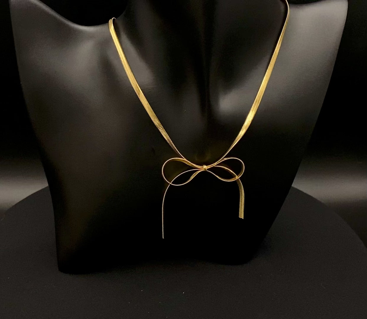 “Celest Angel Bow Pendant Chain in gold with a sophisticated bow pendant design. Made from durable stainless steel, tarnish-free. Measures 35 cm with a 5 cm extender for adjustable fit.”