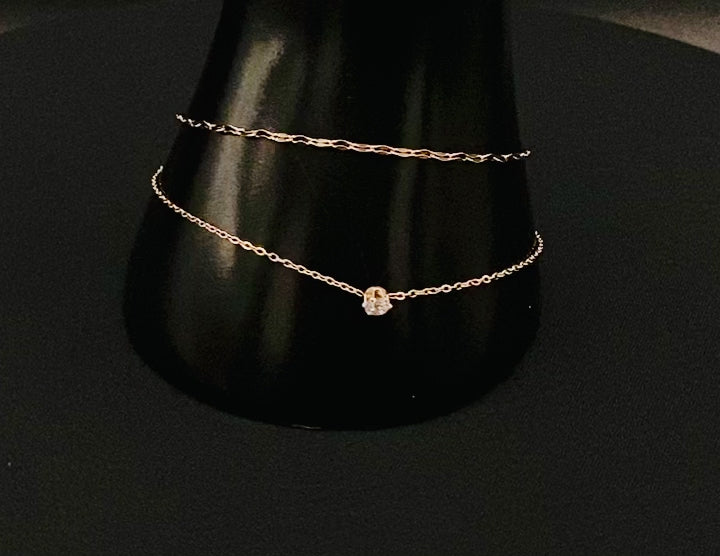 “Aurora Twin Chain Bracelet in rose gold with a sophisticated twin chain design, adorned with zirconia gemstones. Waterproof and measures 18 cm with a 3 cm extender for adjustable fit.”