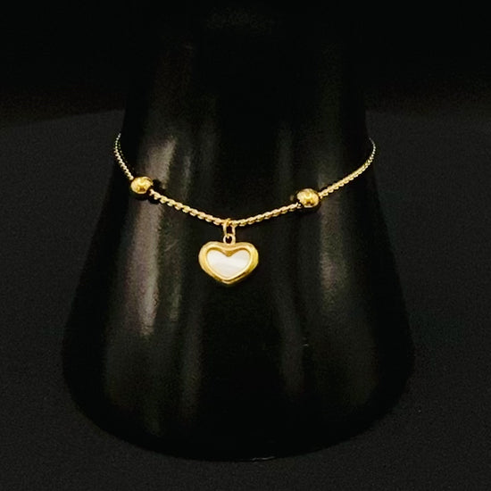 “Helena Heart Bracelet in gold with a white shell heart pendant, crafted from high-quality stainless steel and plated with 18K gold. Adjustable, waterproof, tarnish-free, and environmentally friendly.”