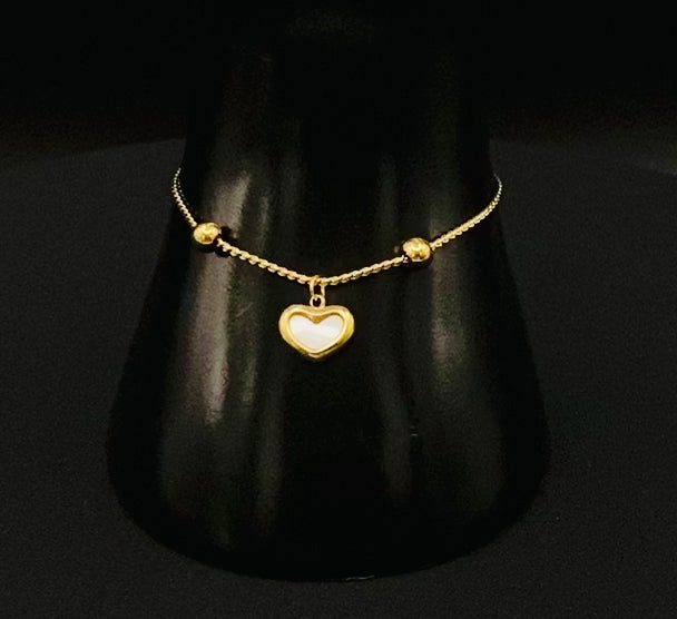 “Helena Heart Bracelet in gold with a white shell heart pendant, crafted from high-quality stainless steel and plated with 18K gold. Adjustable, waterproof, tarnish-free, and environmentally friendly.”