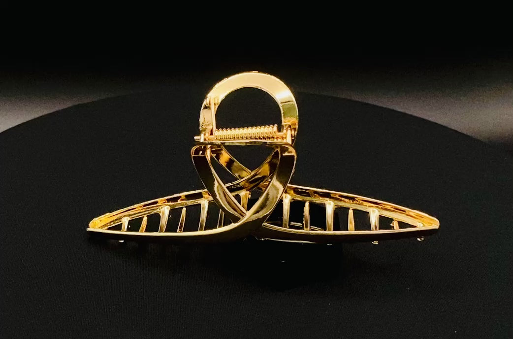 “The Luxe Claw Clip Metal Bow in Gold, crafted from high-quality, durable metal. Measures 11 cm, featuring a luxurious gold finish and unique link design. Perfect for securing various hair types and styles, suitable for both everyday wear and special occasions.”