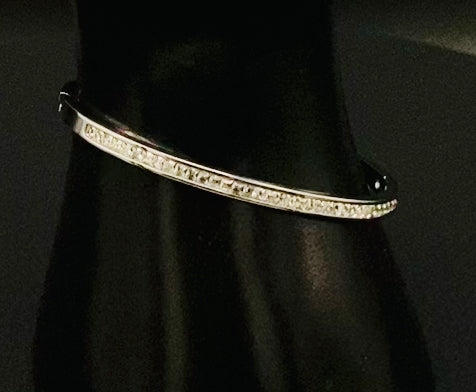“Simone Encrusted Bangle in silver with silver plating and gemstone inlay, offering a radiant and luxurious finish. Durable construction ensures long-lasting wear and tarnish resistance. Perfect for both everyday wear and special occasions.”
