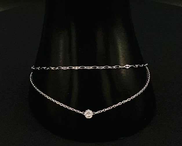 “Aurora Twin Chain Bracelet in silver with a sophisticated twin chain design, adorned with sparkling zirconia gemstones. Waterproof and measures 18 cm with a 3 cm extender for adjustable fit.”