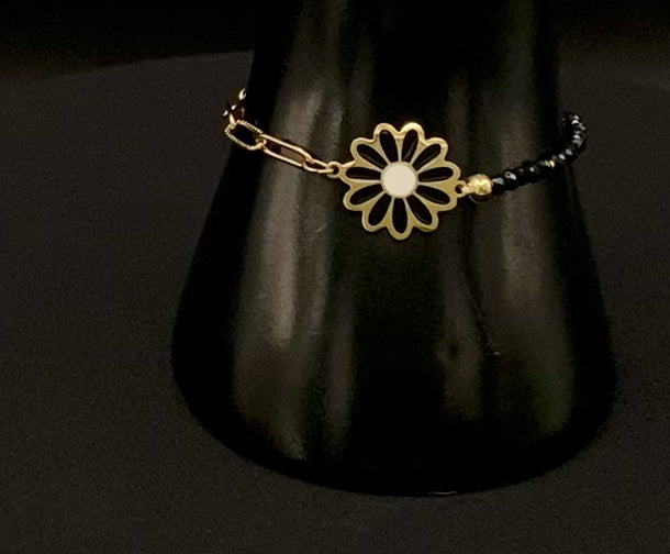 “Daisy Chain Bead Bracelet in black, crafted from stainless steel with 18K gold plating. Features a daisy flower pattern with crystal and rhinestone accents. Eco-friendly, nickel and lead-free, safe for sensitive skin.”