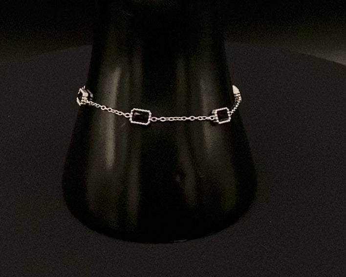 “Clarissa Bracelet in silver with black zircon inset stones, featuring a luxurious silver plating and adjustable length of 17.5 cm with a 2 cm extension. Durable construction ensures long-lasting wear and tarnish resistance.”